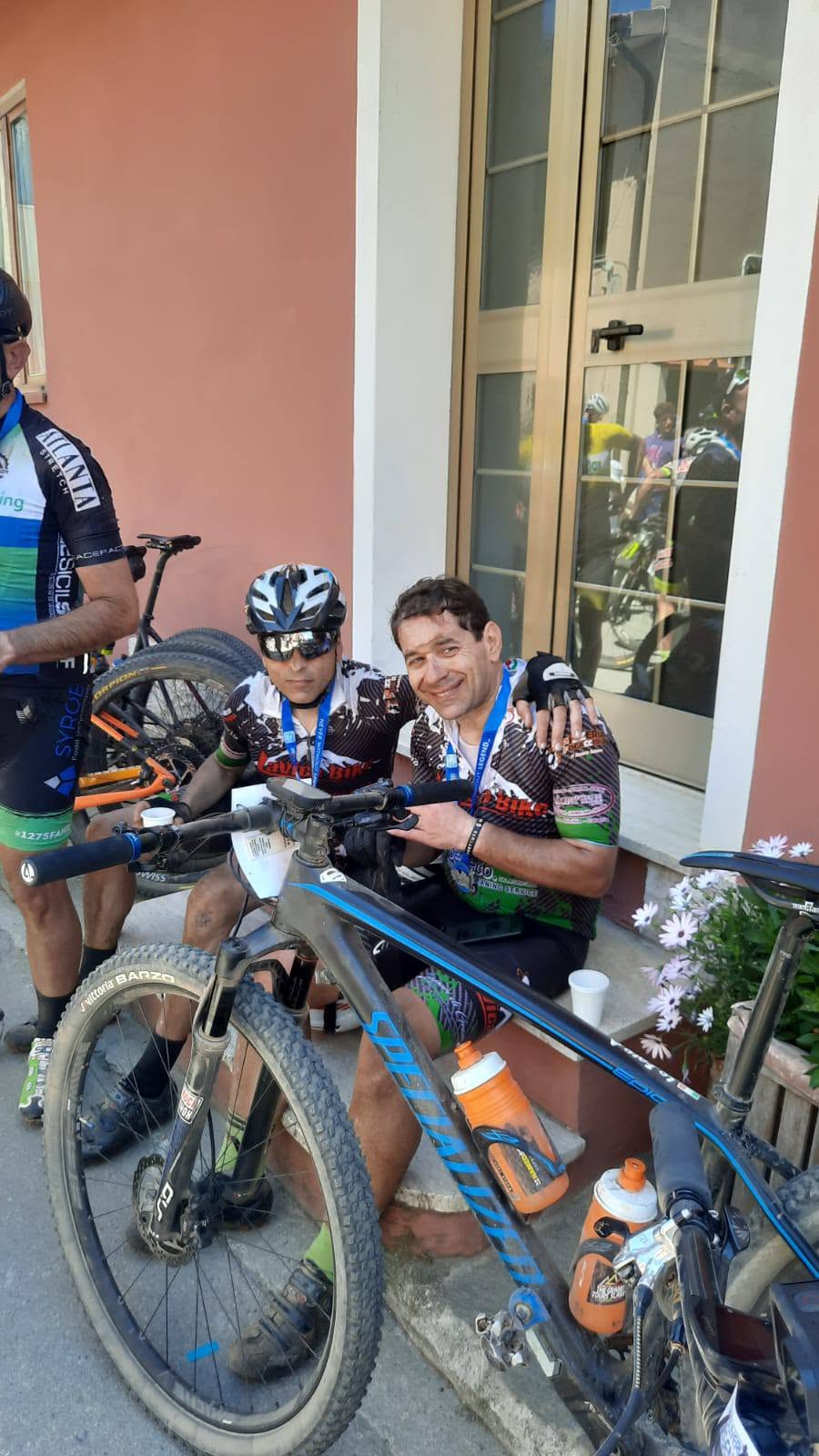 Seduti sul gradino all'arrivo della Capoliveri, con la maglia della Lavica Bike e le bici davanti